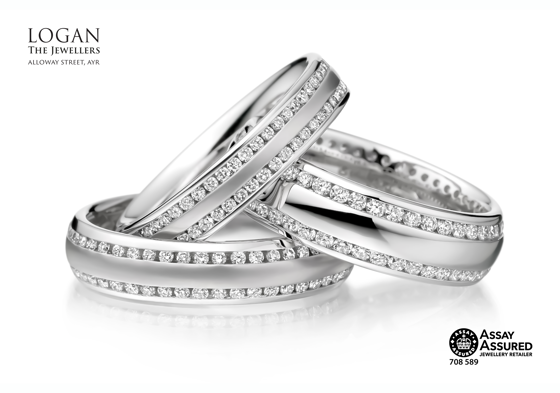 Three silver wedding bands with two thin bands of diamonds on each